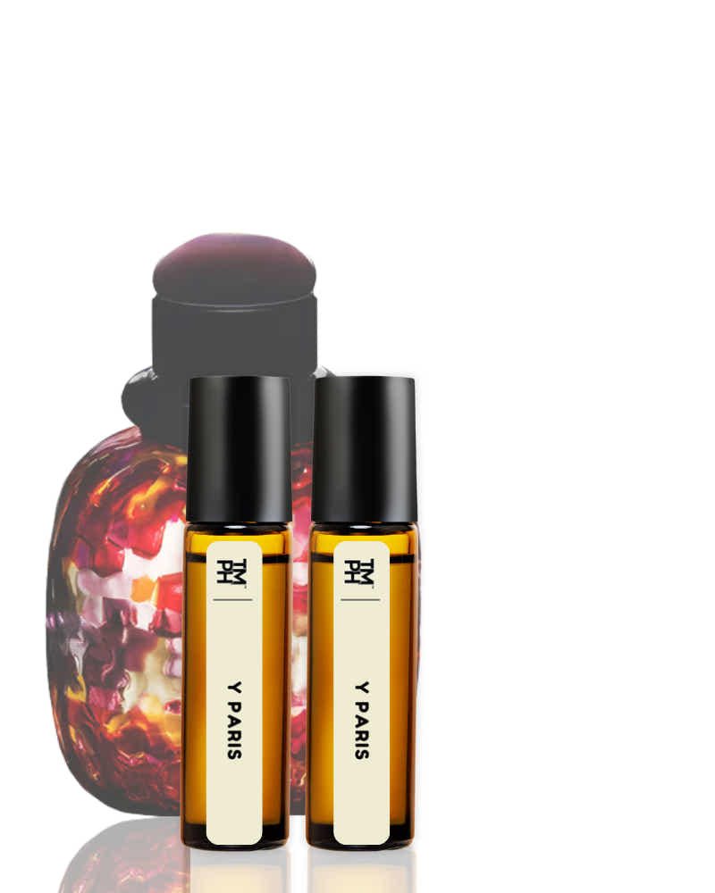 Two small bottles of Y Paris perfume with a larger decorative bottle in the background on a white background