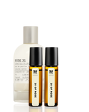 Set of perfume bottles including a large spray bottle and two smaller rollerball bottles on a white background.