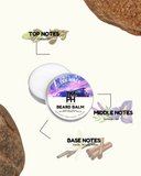 Beard balm container with notes on top, middle, and base scents on a white background.