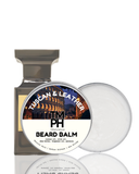Beard balm packaging with 'Tuscan & Leather' scent on a white background